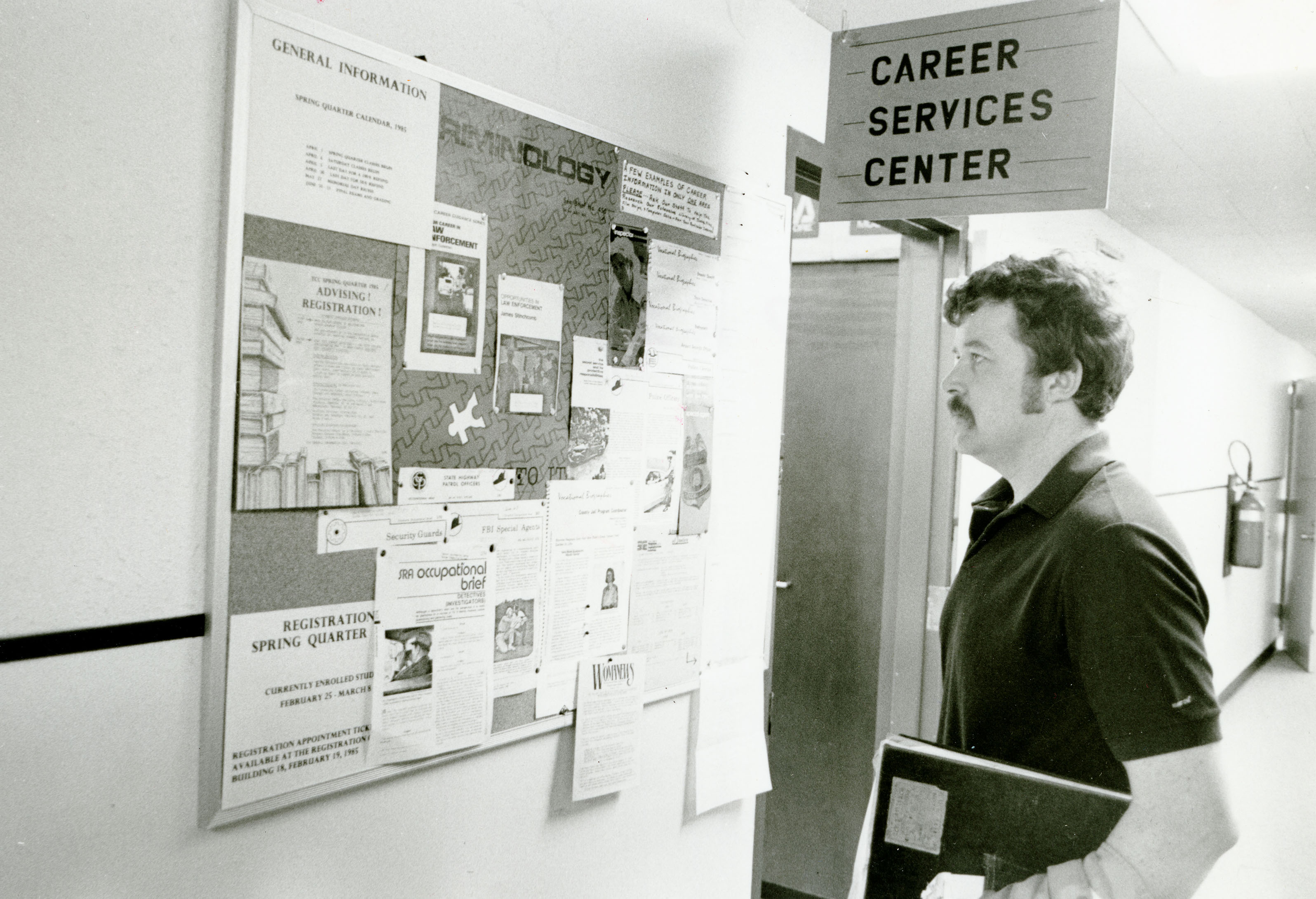 Student looking at job board outside of the Career Center