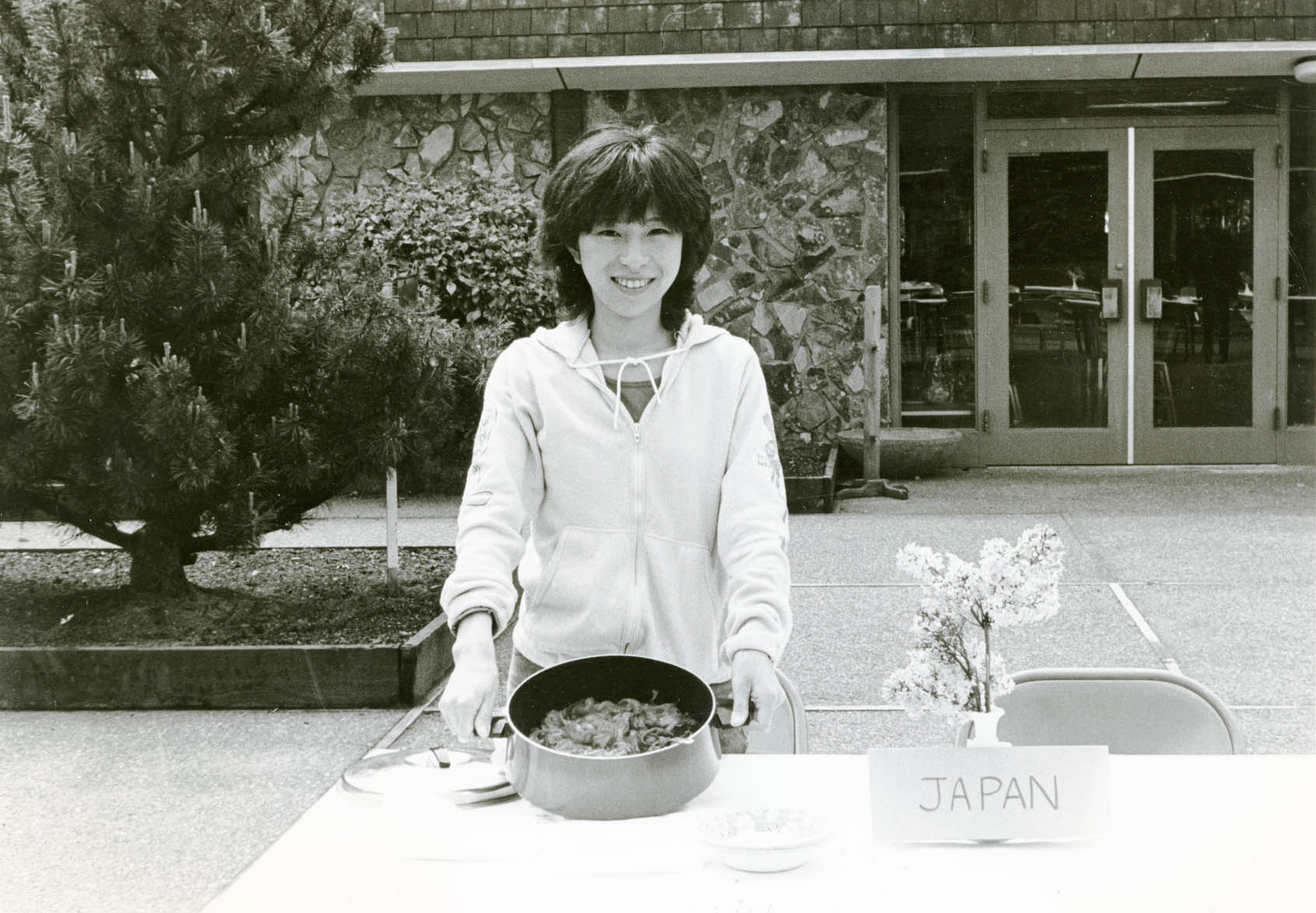 Student at table with food representing Japan at an international food festival