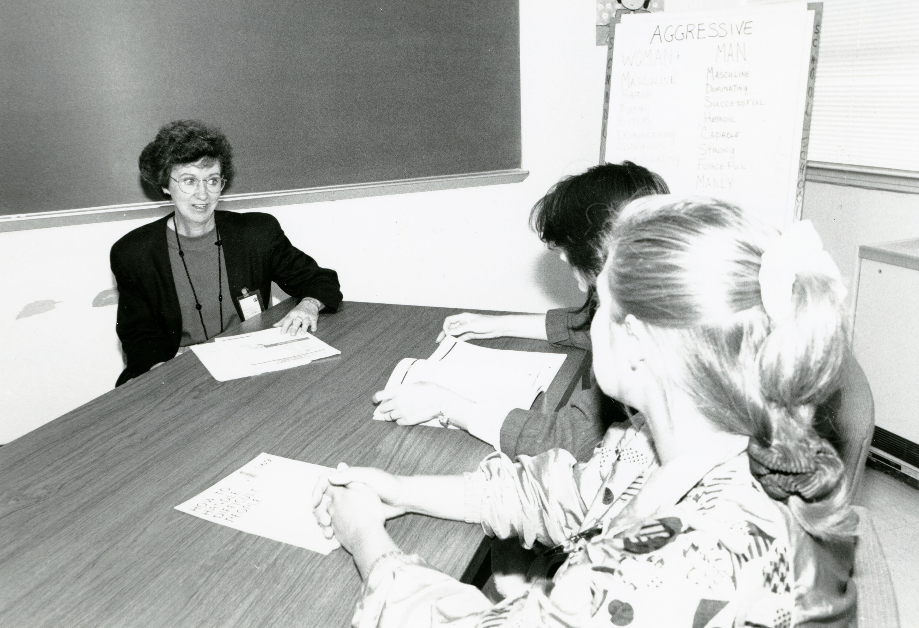 Instructor sitting at table with two students